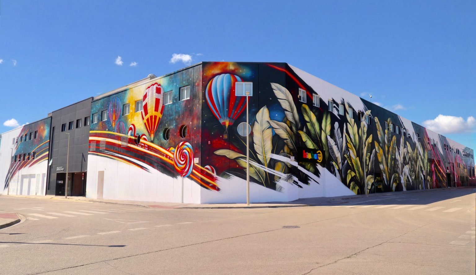 Fachada del Sky Business Center de Manises pintada con el mural de los globos, obra de Keoni VGN